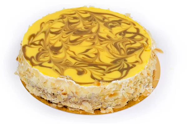 整个圆圆的蛋糕 顶部装饰着黄色果冻 侧面铺着碎坚果 放在纸的白色背景上 — 图库照片
