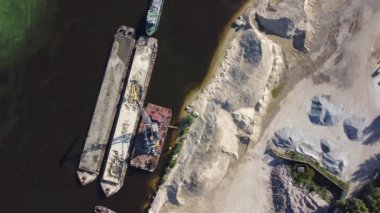 Mavnadan kumu indirirken havada süzülen vinç, dikey görüntü