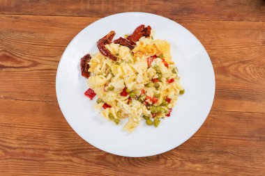 Makarnalı güveç, tabakta güneşte kurutulmuş domates, üst manzara.