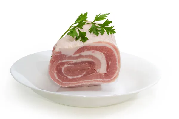 白の背景に白い皿の上に新鮮なパセリの小枝と冷凍ひんやり豚の腹のゆでた部分 — ストック写真