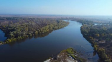Nehir kıyıları ve ada ağaçlarla kaplı, hava manzaralı.