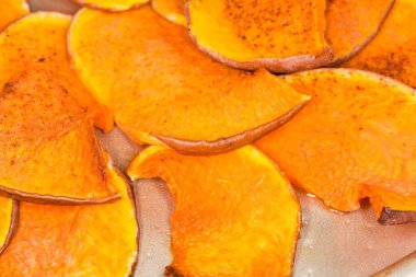 Ev yapımı tatlı cipsler sarı tereyağlı kabak ve üzerine tarçın serpiştirilmiş şeker serpiştirilmiş.