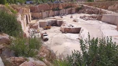 Kırmızı granit bloklar boşaltıcıya yüklenirken taş ocağı forklift yükleyicisi