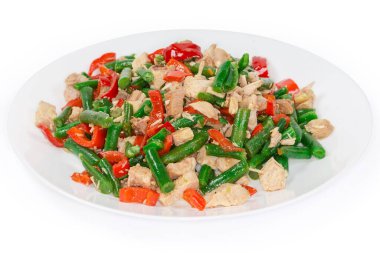 Haşlanmış tavuk etli salata, dilimlenmiş taze dolmalık biber ve beyaz arka plandaki büyük beyaz tabakta Fransız fasulyesi.