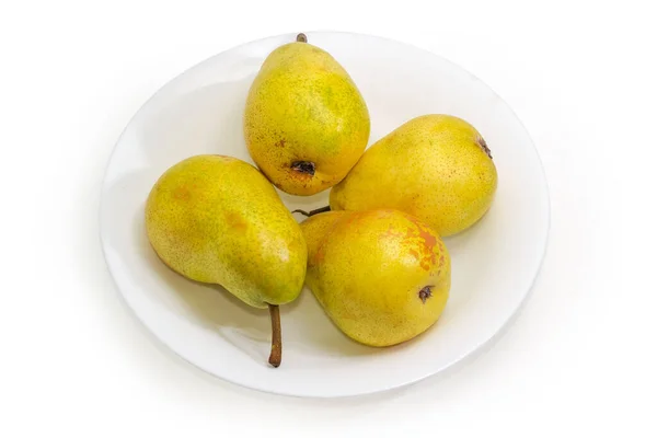 白い背景に白い皿の上に黄色の梨を熟す — ストック写真