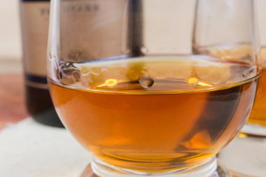 Konyak kasesinde konyak, bardaktan damlayan damlalar, seçici odak noktasında yakın plan.