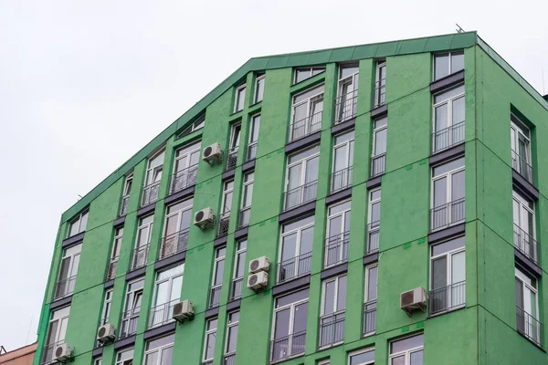 现代多层公寓楼绿色立面的碎片在阴天的映衬下 — 图库照片