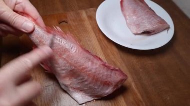 Kesme tahtasındaki balık pullarından kırmızı balığı temizlemek