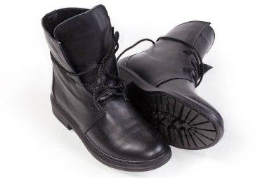 Bir çift siyah deri kadın botu ve beyaz bir arka plan.