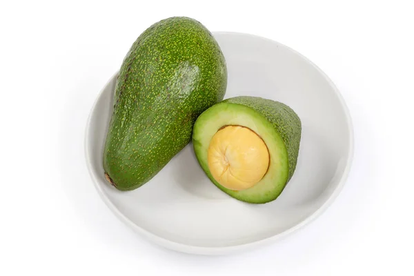 One Whole Unpeeled Half Ripe Green Avocado Fruit White Saucer — 图库照片