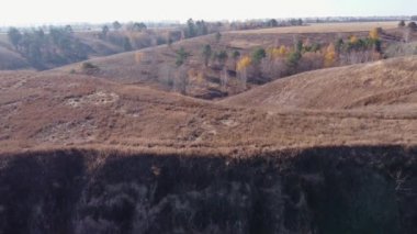 Geçitli vadi, tek ağaçlar, kuru otlar, hava manzaralı.