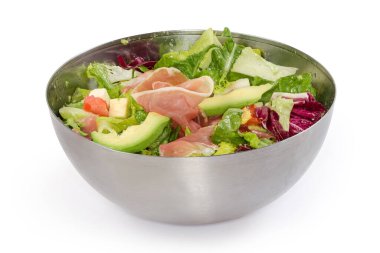 Yeşil ve kırmızı marul yapraklı salata, diğer taze sebzeler, avokado, yumuşak peynir ve ince dilimler metal kasede, beyaz arka planda yan görünüm