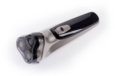 Üç döner bıçaklı ve pervanelerin üzerine sabitlenmiş, beyaz bir yüzeye şarj edilebilir pille donatılmış modern elektrikli traş makinesi.