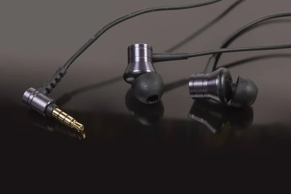 Par Auriculares Oído Alambre Enchufe Audio Una Superficie Reflectante Oscura —  Fotos de Stock