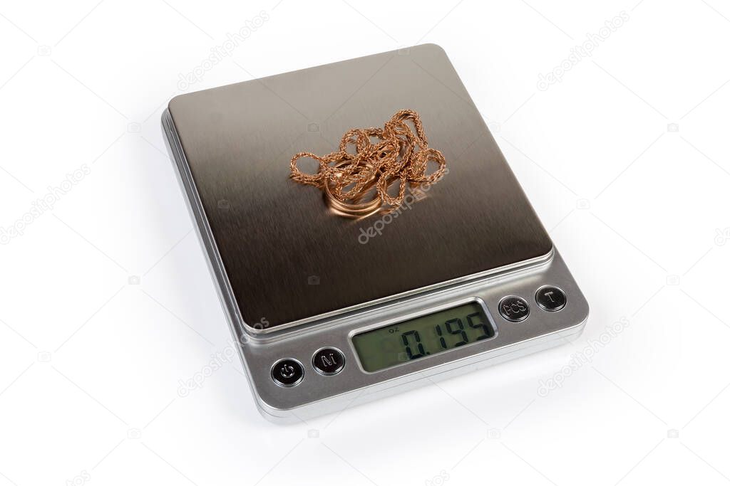 Professional high precision digital table top scales with LCD display and weighable gold jewelry on them on a white background