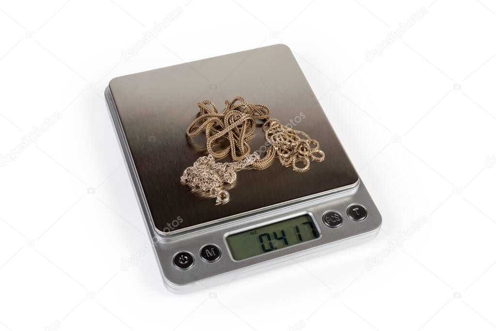 Professional high precision digital table top scales with LCD display and weighable silver jewelry on them on a white background