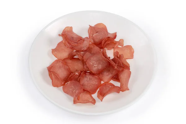 白い背景に白い皿の上に鶏の肉を硬化させた薄切りの形でスナック — ストック写真