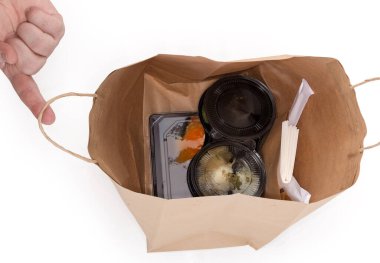 Open disposable packaging bag made with light brown kraft paper with twisted paper rope handles for food delivery with fast food, top view on a white background