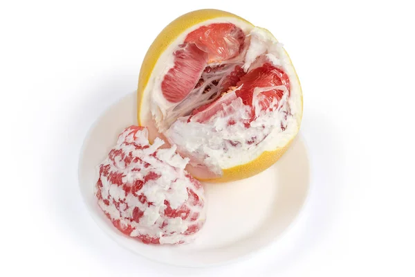 红色品种的石榴皮片和白色背景的白盘上的同一种水果的未剥皮休息部分 — 图库照片