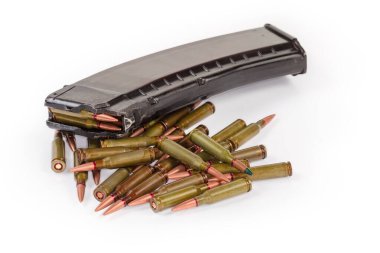 Heap of the service rifle cartridges against the loaded assault rifle magazine on a white background, close-up in selective focus clipart