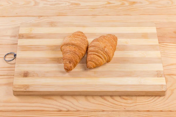 Dos Croissants Pequeños Hechos Con Hojaldre Tabla Cortar Bambú Madera — Foto de Stock