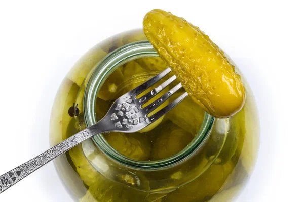 叉子上的罐头黄瓜放在开着的大罐子上 上面有同样的黄瓜 顶部是白色的背景 — 图库照片