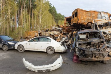 IRPIN, UKRAINE - 27.2022 Nisan: Rus askerleri tarafından Rus işgali sırasında silahsız insanların savaş alanından çıkarılması sırasında vurulan ve yakılan sivil arabaların kalıntıları, araba mezarlığı