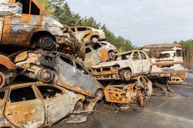 IRPIN, UKRAINE - 27.2022 Nisan: Rus askerleri tarafından Rus işgali sırasında silahsız insanların savaş alanından çıkarılması sırasında vurulan ve yakılan sivil arabaların kalıntıları, araba mezarlığı