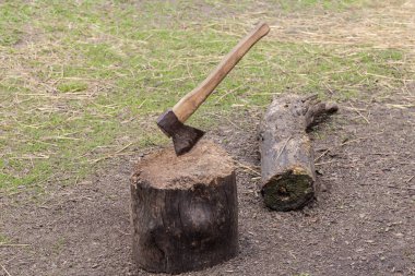Bir avluda tahta bloğa balta darbesi