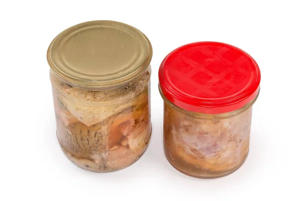 用两个密封的小玻璃瓶把猪肉和罐装鱼放在自己的果汁里 白色底座上 — 图库照片