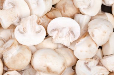 Raw fresh sliced cultivated white button mushrooms, top view close-up