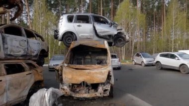 Irpin, Ukraine - April 27, 2022: Remains of the civil cars which was shot up and burned out by Russian soldiers during evacuation of unarmed peoples from war zone in Russian invasion, car graveyard 