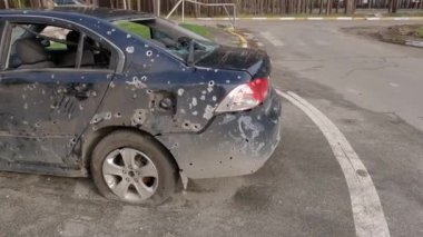 Irpin, Ukraine - April 27, 2022: Side part of the civil car which was shot up by Russian soldiers during evacuation of unarmed peoples from war zone in Russian invasion of Ukraine, car graveyard 