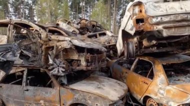 Irpin, Ukraine - April 27, 2022: Remains of the civil cars which was shot up and burned out by Russian soldiers during evacuation of unarmed peoples from war zone in Russian invasion, car graveyard 