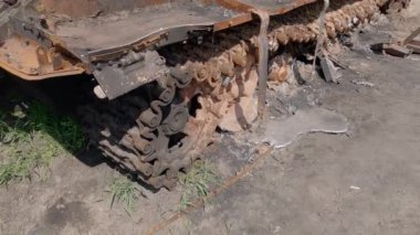 Kyiv bölgesi, Ukrayna - 29 Nisan 2022: Rusya 'nın Ukrayna' yı işgali sırasında bir otoyol kenarında yerle bir ettiği taret ile yanmış Rus tankı. Erimiş pist silindirli paslı iz. 