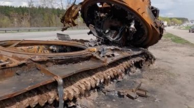 Kyiv bölgesi, Ukrayna - 29 Nisan 2022: Paslı Rus tankı Rusya 'nın Ukrayna' yı işgalinde bir otoyol kenarında imha edildi. Yıkılmış taret, namlu ağzı yere sıkışmış.. 