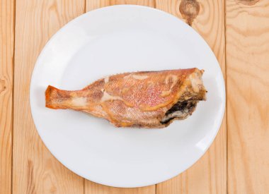 Okyanus levreği leşi, ekşi krema sosu ile pişirilmiş, kırsal masada beyaz tabak, üst manzara.