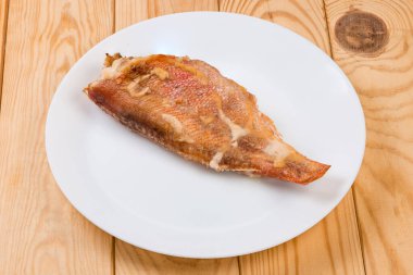 Okyanusun leşi, ekmek sosuyla pişirilmiş, kırsal masada beyaz tabakta.