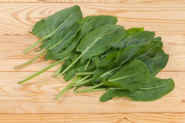 Bunch of the freshly picked leaves of the garden sorrel on a rustic table, top view