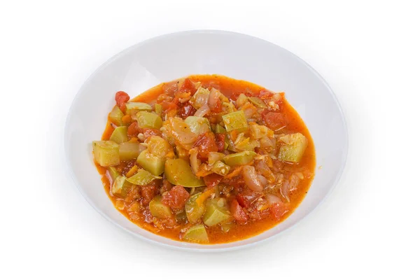 Portion of the vegetable marrow stewed with tomatoes and other vegetables in the white bowl on a white background