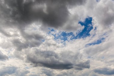 Fragment of the sky almost completely covered with cumulus and storm clouds