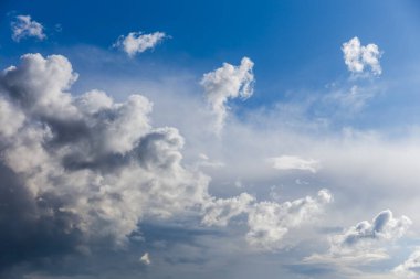 Fragment of the sky partly covered with cumulus and storm clouds
