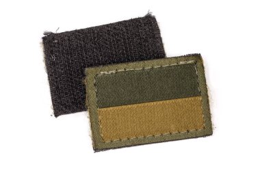Two textile Ukrainian flag stickers in a camouflage drab and tan color scheme on an olive base with hook-and-loop fasteners close-up on a white background, view from two sides