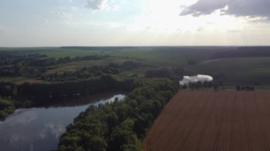 Ponds with forests on banks among agricultural field, aerial view