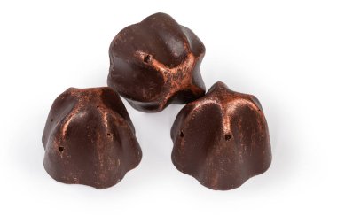 Whole chocolate truffles of conical curved  shape with liquor filling on a white background, close-up