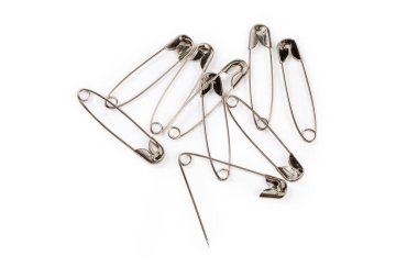 One open and several closed metal safety pins, top view close-up on a white background
