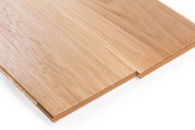 Two connected three-layer engineered wood flooring boards with white oak face layer, pine core layer and glue-less locking joint system, fragment close-up on a white background
