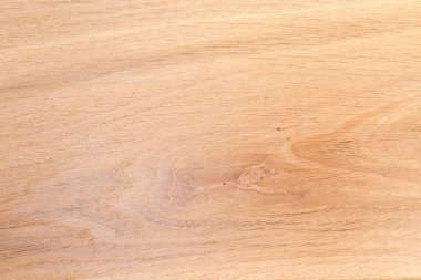 Texture of the wooden surface on the longitudinal cut of the light colored oak plank with small knot, top view close-up, background