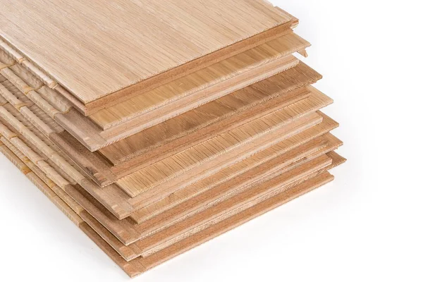 Stack of the three-layer engineered wood flooring boards with white oak face layer, pine core layer and glue-less locking joint system, fragment of butt-end parts close-up