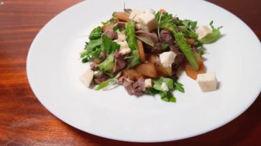 Ahşap masada kaynamış ördek etiyle salata.